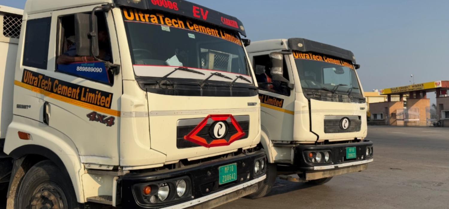 A couple of trucks stand together on a tarred road